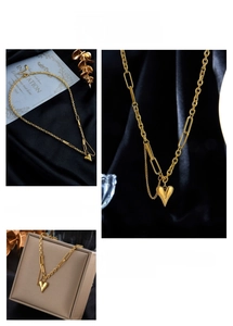 Detailed close-up of gold heart pendant with asymmetrical oval and ring chain necklace