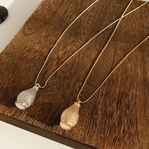 Detail of woven texture and polished mirror finish on teardrop pendant necklaces