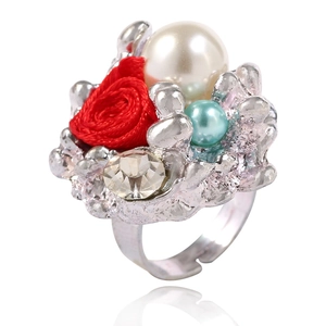 Détail d'une bague fleur en rose et perle avec pétales en tissu rouge et cristaux