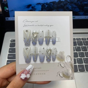 Detail of handmade blue-purple gradient press-on nails with rhinestones and metal chains