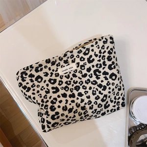 Detailed view of leopard print canvas makeup bag with a zipper and brand label
