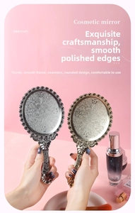 Close-up of vintage floral engraved handheld makeup mirror in gold and silver finish