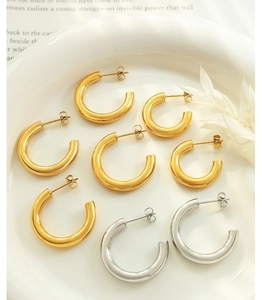 Detailaufnahme minimalistischer Creolen in Gold und Silber in verschiedenen Größen