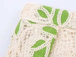 Détail macro de la maille crochet beige et verte avec motif floral ajouré élégant