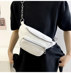 Close-up of a white PU leather waist bag featuring silver zippers and a stylish chain strap
