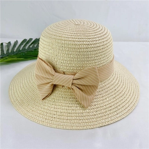 Detail of a beige straw sun hat featuring a striped ribbon bow and woven texture