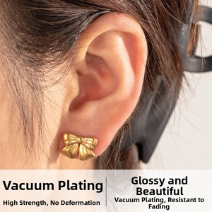 Macro shot of gold bow stud earrings featuring high-shine vacuum plating on the ear