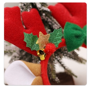 Close-up of Christmas reindeer headband with red antlers, green bow and gold stars