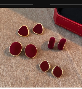 Close-up of vintage geometric earrings with red flocking and gold metal edges