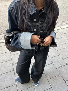Gros plan d'une veste en jean, d'un pantalon noir et d'un sac en cuir tressé chic