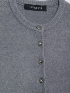 Dettaglio ravvicinato del cardigan grigio in maglia con bottoni metallici argentati