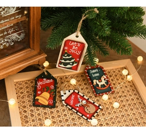 Gros plan de pendentifs de Noël en bois peint avec corde de jute sur une branche