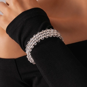 Three-layer clear crystal bead bracelet styled on a black sleeve for an elegant look
