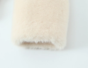 Macro view of plush cream faux fur material showing the soft texture and dense fibers