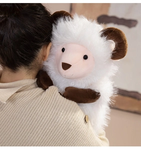 Close-up of soft fluffy white plush goat toy being held to show texture and scale
