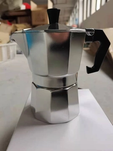 Close-up of a classic silver aluminum moka pot with an octagonal base and black handle