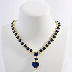 Luxurious gold heart necklace with dark blue zircons displayed on a neck model