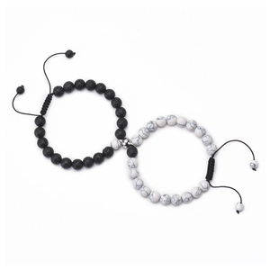 Dettaglio di bracciali magnetici per coppia con pietre laviche nere e perle bianche