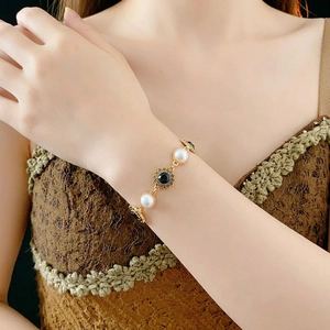 Vintage gold-plated bracelet with artificial pearls and black sun-pattern center stone
