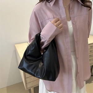 Minimalist black faux leather tote bag with soft folds and single handle design