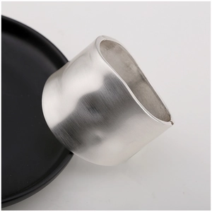 Detail view of a wide silver metal bracelet with a minimalist brushed texture finish