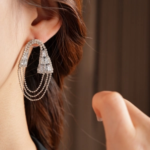 Primo piano di orecchini geometrici con nappe in zircone indossati da una modella