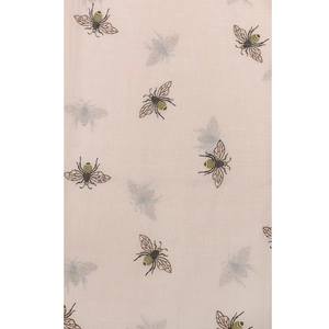 Detailed close-up of bee print fabric with gold and grey motifs on a beige background