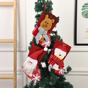 Three Christmas stockings with Santa, reindeer and snowman hanging on a tree