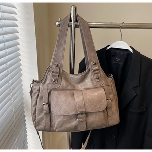 Detail of vintage grey-brown PU leather tote bag with functional pockets and buckle straps