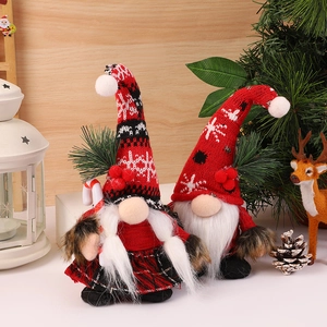 Detailed view of Christmas gnomes with knit hats, long white beards and festive candy canes