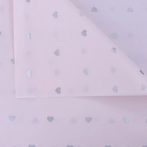 Detailed view of pink tissue paper with silver heart patterns for flower wrapping