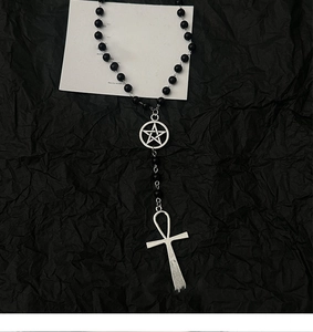 Détail du pendentif croix ankh gothique et breloque étoile sur collier perlé noir