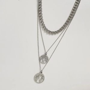 Three-layer silver necklace with tree of life and world map charms on a curb chain