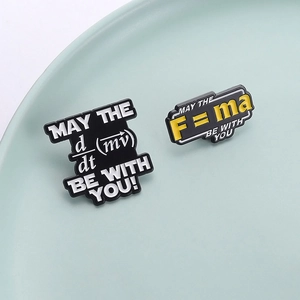 Black enamel physics badges with May the F=ma Be With You text on a ceramic plate