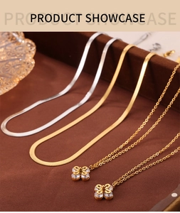 Detail of gold clover pendant necklace and flat snake chain with cubic zirconia stones