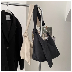 Detail of minimalist canvas crossbody bag with unique knot shoulder strap and zip closure