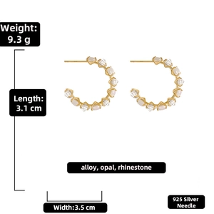 Detailed view of gold C-shaped earrings with faux opal, rhinestones, and size measurements