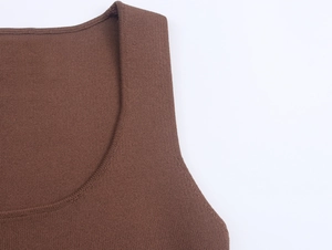 Dettaglio macro dello scollo e delle cuciture sulle spalle di un abito in maglia marrone