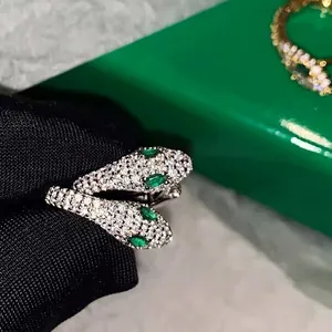 Macro shot of silver snake earrings featuring sparkling zircon micro-pave and emerald eyes