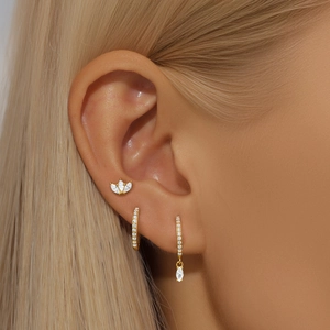 Close-up of S925 silver gold earrings set with white zircon stones on model ear