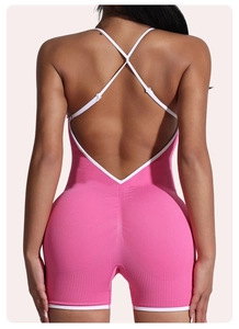Detailed back view of pink ribbed yoga romper with white criss-cross back straps