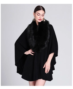 Detail view of black knit shawl poncho with luxurious faux fox fur collar and elegant drape