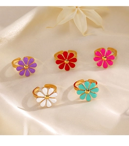 Set of five adjustable gold daisy rings with colorful enamel flower petals on beige silk