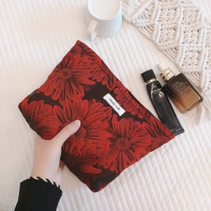 Canvas makeup bag with blue floral relief pattern and secure zip closure for travel
