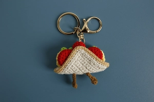 Close-up of handmade crochet taco keychain with colorful fillings and metal clasp