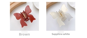 Detail of coffee brown and creamy white butterfly hair claws with shiny finish