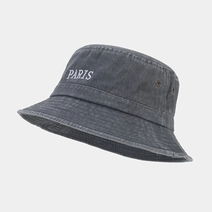 Close-up of white PARIS embroidery and metal eyelets on vintage washed black bucket hat