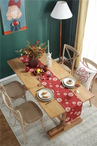 Detailed top view of red Christmas table runner featuring white snowflake patterns on cotton