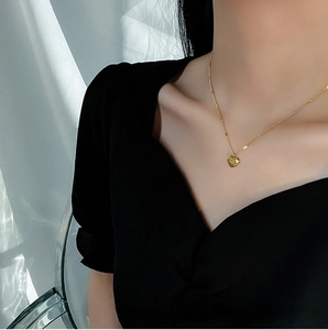 Elegant gold-plated stainless steel heart pendant necklace for women on a model