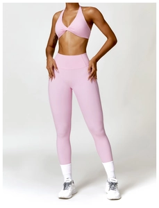 Vue détaillée d'un ensemble de yoga rose avec haut torsadé et legging taille haute sans couture